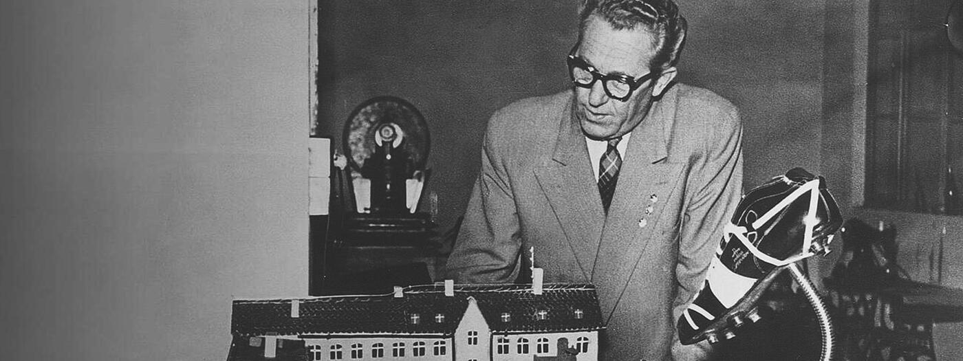 Rudolf Dassler looking at a miniature house