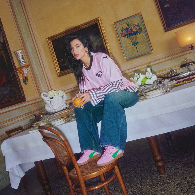 Dua Lipa sitting on a table