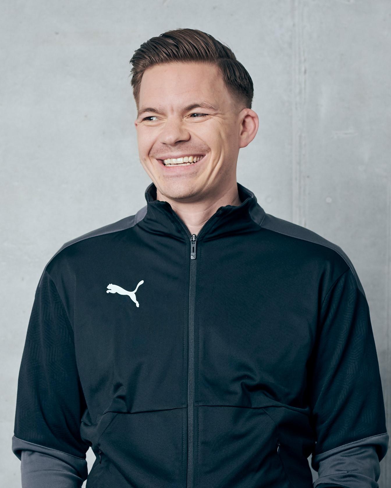 PUMA employee Gary smiling with a black jacket