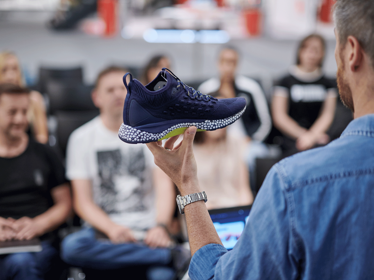 PUMA employee showcasing a new PUMA shoe to an audience