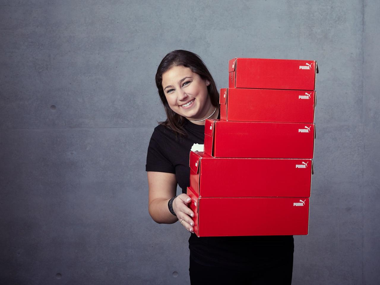 Katie Vachon holding PUMA Cardboard boxes