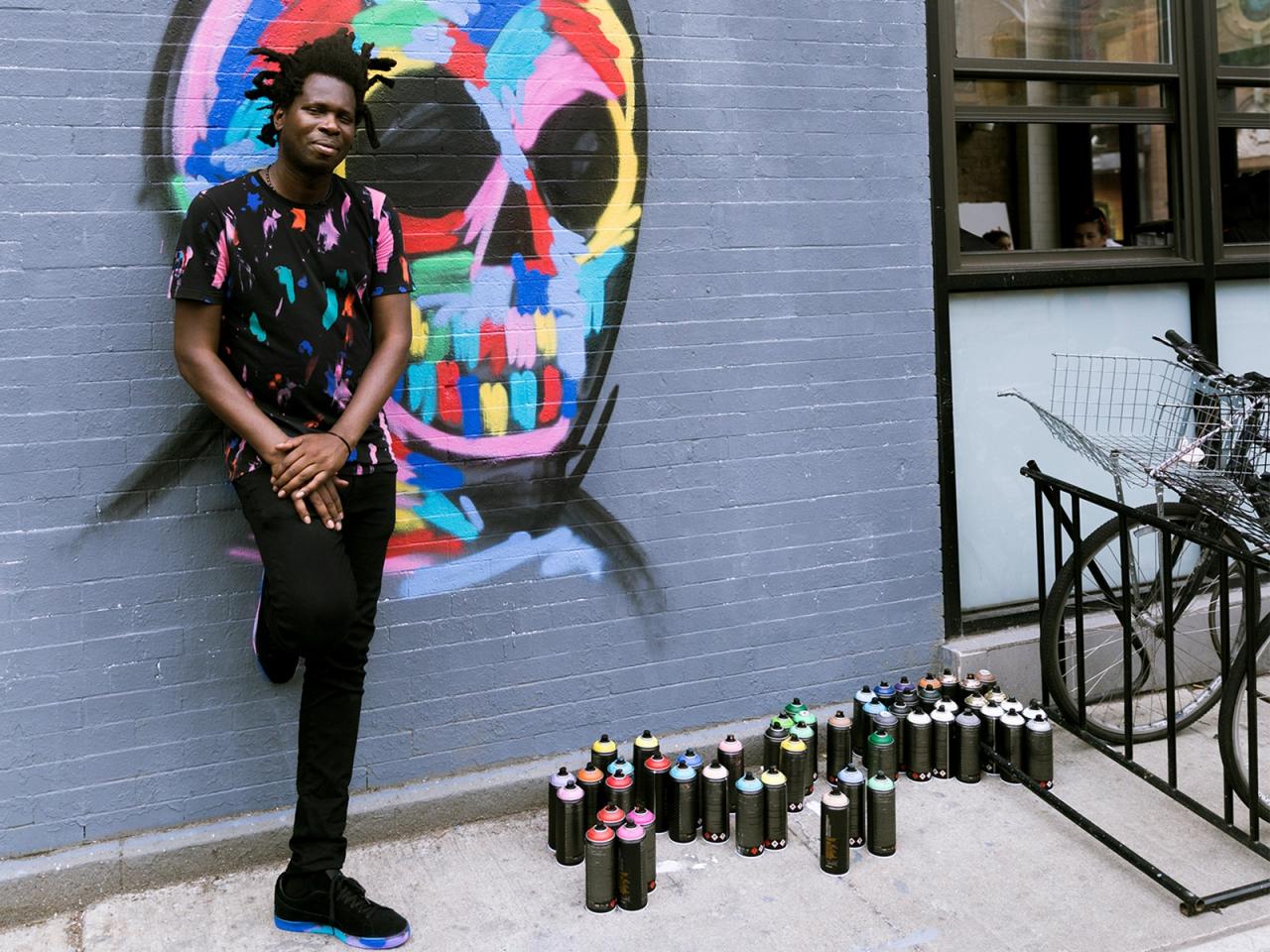 A man standing next to graffiti