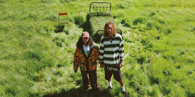 A couple standing on a grass field wearing PUMA clothes